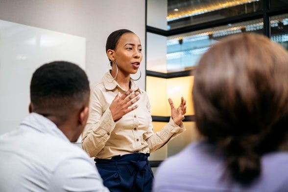 Young businesswoman passionately explaining topic to colleagues