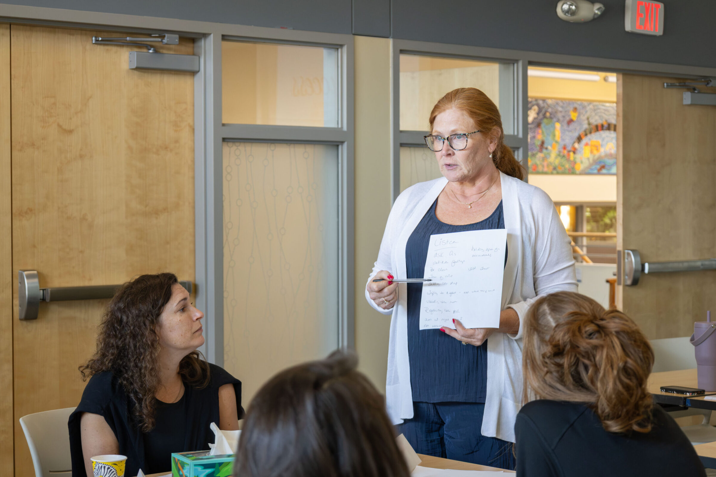 A woman reviewing a document during a presentation