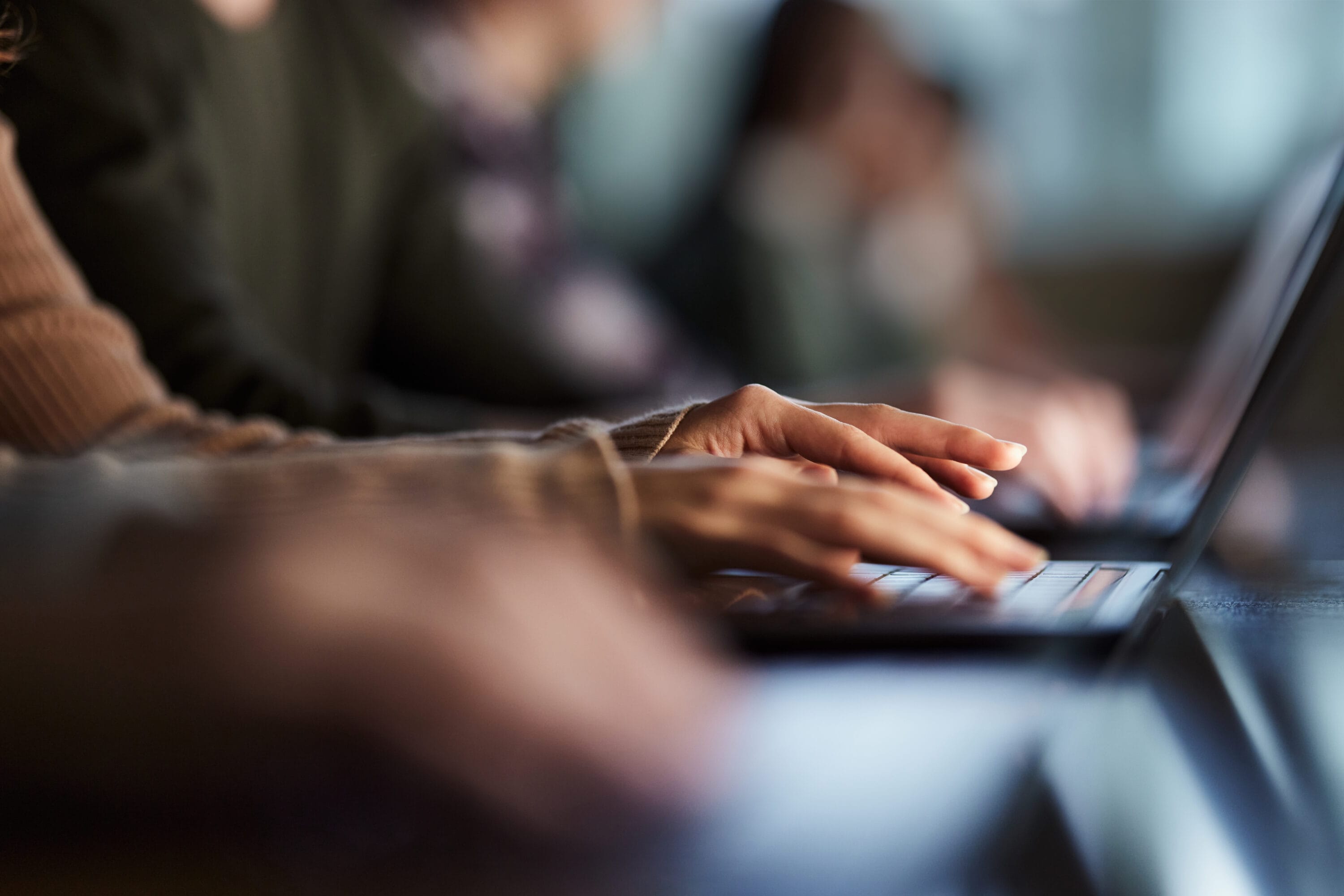 A pair of hands working on a laptop.